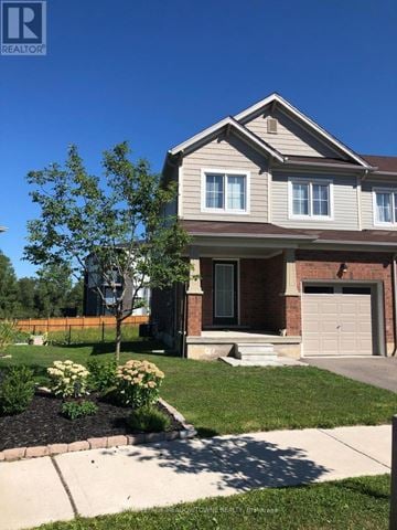 Brantford townhouse for rent - A house with a brown roof and a white garage door.