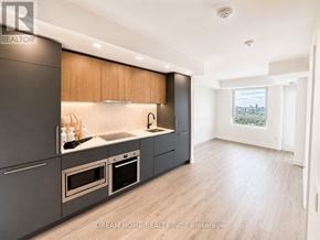 Toronto (North St. James Town) condo for rent - A modern kitchen with wooden cabinets and stainless steel appliances.