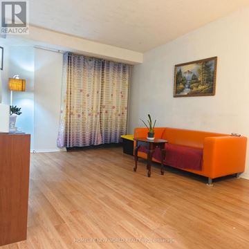Toronto (West Hill) condo for rent - A living room with a couch, a table, and a painting on the wall.
