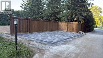 Aurora (Bayview Southeast) apartment for rent - A wooden fence surrounds a driveway with a lamp post on the left.
