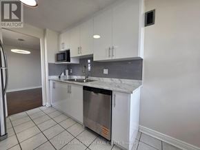 Brampton (Brampton 407 Corridor) condo for rent - A kitchen with white cabinets and a stainless steel dishwasher.