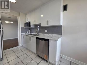 Brampton (Brampton 407 Corridor) condo for rent - A kitchen with white cabinets and a stainless steel dishwasher.