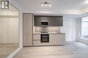 Toronto (Waterfront Communities) condo for rent - A modern kitchen with a large island and a microwave above it.