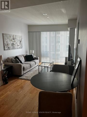 Toronto (Waterfront Communities) condo for rent - A living room with a grey couch and a black table.