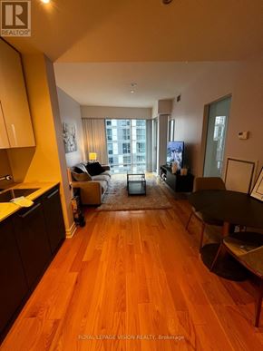 Toronto (Waterfront Communities) condo for rent - A living room with a couch, chairs, and a television.