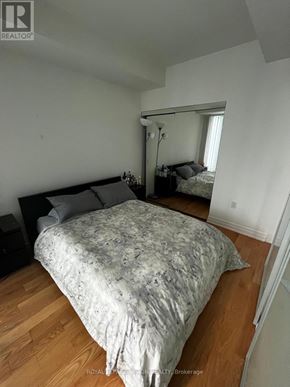 Toronto (Waterfront Communities) condo for rent - A bedroom with a large bed and a mirror on the wall.