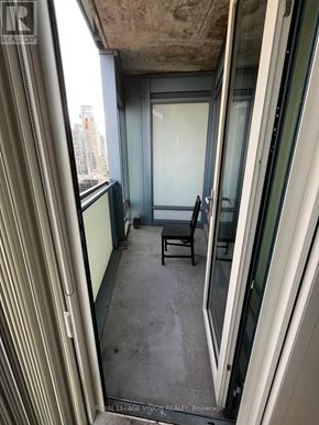Toronto (Waterfront Communities) condo for rent - A view from inside a building looking out through a window into a hallway with a bench.