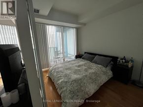 Toronto (Waterfront Communities) condo for rent - A bedroom with a large bed and a window with blinds.