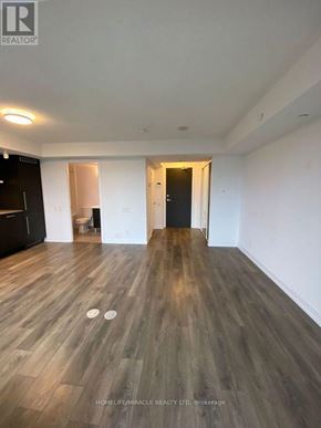 Toronto (Church-Yonge Corridor) condo for rent - A spacious room with wooden flooring and white walls.