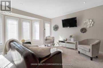 Milton (Wi Willmott) townhouse for rent - A living room with a brown leather couch and a white armchair.
