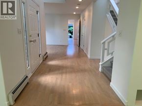 Vancouver apartment for rent - A hallway with wood floors and white walls.