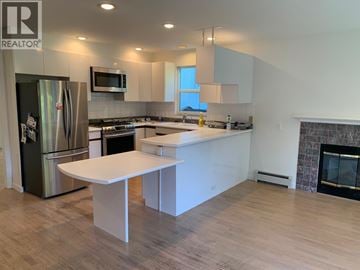 Vancouver duplex for rent - A modern kitchen with a refrigerator, stove, and island.