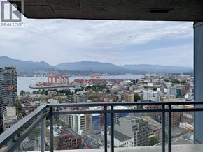 Vancouver apartment for rent - A cityscape with a view of a bay and mountains in the distance.