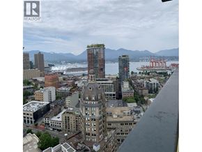 Vancouver apartment for rent - A cityscape with a large body of water and mountains in the background.