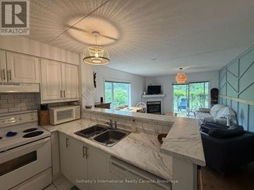 Collingwood townhouse for rent - A kitchen with white cabinets and a marble countertop.