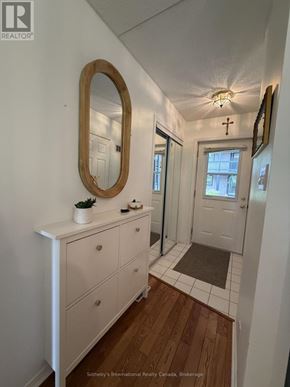 Collingwood townhouse for rent - A white bathroom with a wooden floor and a round mirror.