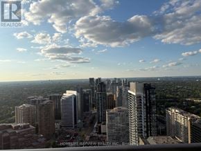 Toronto (Willowdale East) condo for rent - A cityscape with skyscrapers and a cloudy sky.