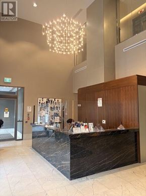 Mississauga (Hurontario) condo for rent - A reception area with a wooden counter and a chandelier.