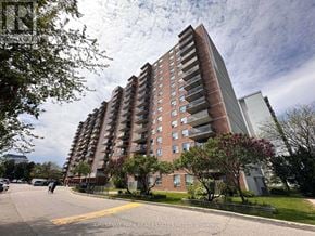 Mississauga (Lakeview) multi-family for rent - A large apartment building with a parking lot in front.