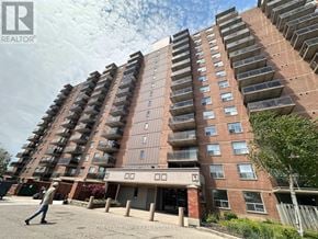 Mississauga (Lakeview) multi-family for rent - A tall residential building with a man walking in front.