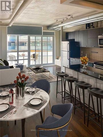 Toronto (South Parkdale) condo for rent - A modern kitchen with a bar area and a dining table set for two.