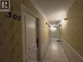 Windsor multi-family for rent - A hallway with a door on the left and a fire extinguisher on the wall.