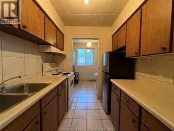 Windsor multi-family for rent - A kitchen with wooden cabinets and a black refrigerator.