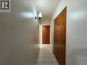Windsor multi-family for rent - A hallway with two doors at the end and a light on the wall.