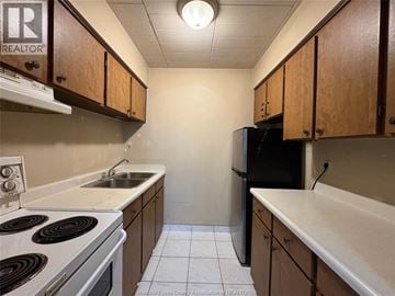 Windsor multi-family for rent - A kitchen with a stove top oven, sink, and refrigerator.