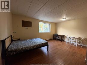 Windsor multi-family for rent - A bedroom with a bed, chair, and table.