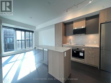 Toronto (Regent Park) condo for rent - A modern kitchen with wooden cabinets and stainless steel appliances.