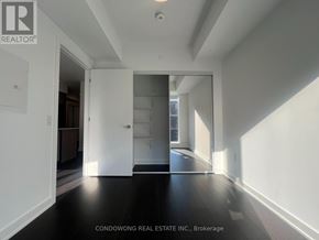 Toronto (Regent Park) condo for rent - A spacious room with white walls and a black floor.