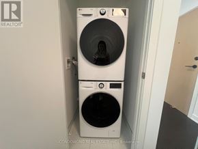 Toronto (Regent Park) condo for rent - A white dryer and washer in a small laundry room.
