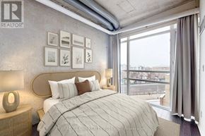 Toronto (Little Portugal) condo for rent - A bedroom with a large bed and a view of the city.