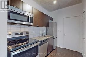 Toronto (Little Portugal) condo for rent - A kitchen with a stove top oven, microwave, and dishwasher.