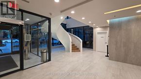 Toronto (Church-Yonge Corridor) condo for rent - A modern interior space with a glass door entrance and a staircase.