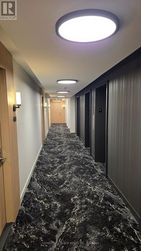 Toronto (Church-Yonge Corridor) condo for rent - A long hallway with marble flooring and doors on the right.