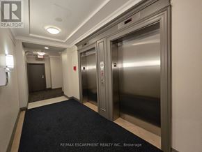 Oakville (Ro River Oaks) condo for rent - A hallway with a brokerage sign on the wall.