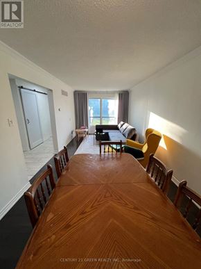 Brampton (Brampton West) apartment for rent - A long wooden table is in the middle of a room with chairs on either side.