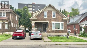 Waterloo apartment for rent - A red car is parked in front of a house with a sign that says "REALTOR".