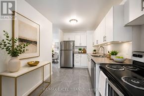 Toronto (Dorset Park) condo for rent - A modern kitchen with white cabinets and a black stove top.