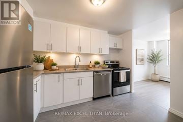 Toronto (Dorset Park) condo for rent - A modern kitchen with white cabinets and stainless steel appliances.