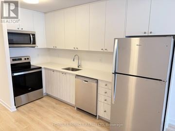 Kitchener townhouse for rent - A kitchen with white cabinets and a stainless steel refrigerator.