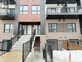 Kitchener townhouse for rent - A building with a red door and black railings.