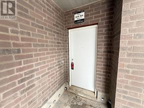 Kitchener townhouse for rent - A white door with a red handle is in a brick wall.