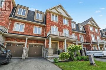 Hamilton (Waterdown) townhouse for rent - A large red brick house with a car parked in front.