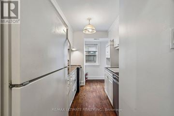 Toronto (Yonge-Eglinton) multi-family for rent - A white refrigerator is on the left side of a narrow kitchen.