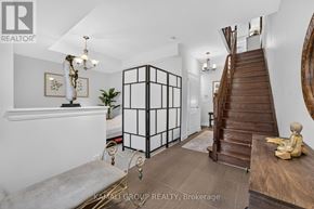 Vaughan (Beverley Glen) townhouse for rent - A white room with a wooden staircase and a chandelier.