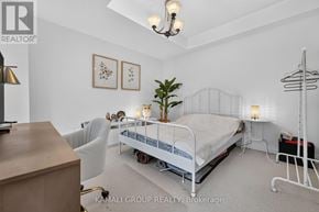 Vaughan (Beverley Glen) townhouse for rent - A bedroom with a bed, chair, and a plant.