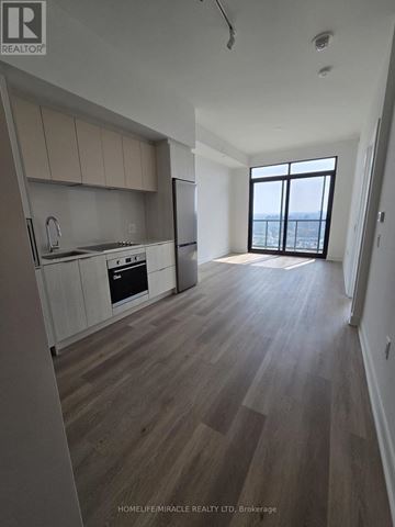 Mississauga (Cooksville) condo for rent - A spacious kitchen with wooden floors and a large window.